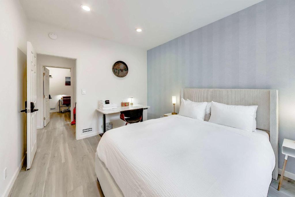 a bedroom with a large white bed and a desk at 3BR recently renovated SOMA flat in San Francisco