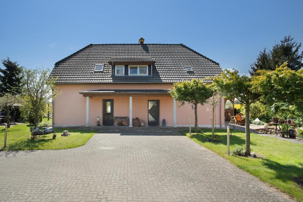 a house with a gambrel roof on a brick driveway at Ferienwohnung Lüssow in Lüssow