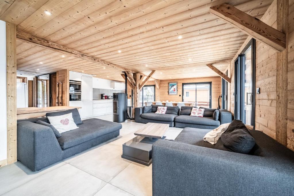 a living room with two blue couches and a table at Martonne - haut Roca immobilier in Châtel