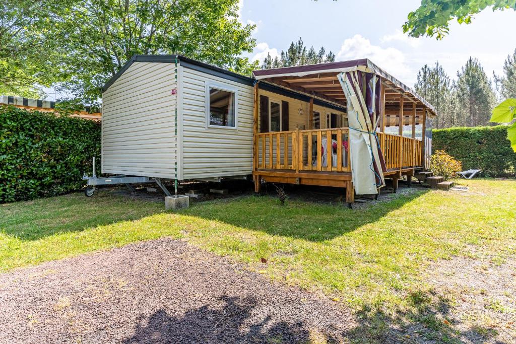 a tiny house with a gazebo in a yard at Mobilehome au bord de l'eau in Gastes