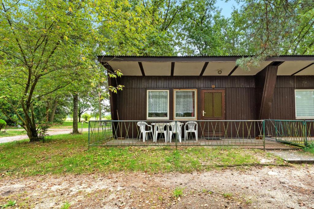 a small house with two chairs and a porch at Bungalow 4 - Kimbucht in Reichendorf