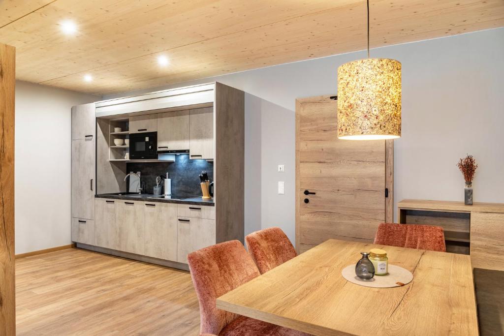 a kitchen and dining room with a wooden table and chairs at Ferienwohnung Hirsch-Loge in Pflach