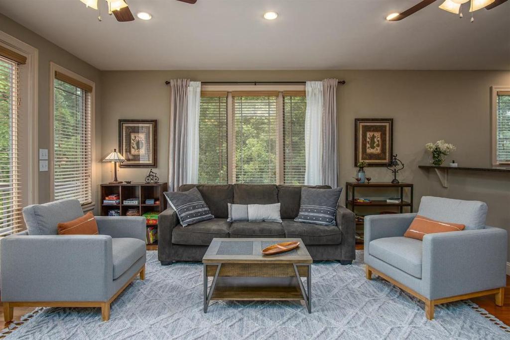 ein Wohnzimmer mit einer Couch, zwei Sesseln und einem Tisch in der Unterkunft Brevard Basecamp · Brevard Basecamp fireplace in Primary BR in Brevard