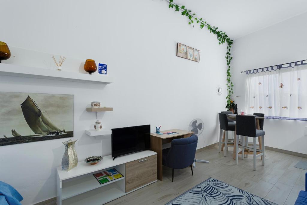 a living room with a desk with a tv and a table at Villa Monica in Agüimes