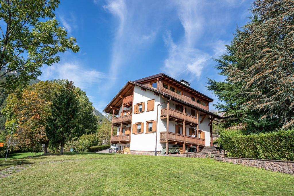 a large house with a grassy field in front of it at Casa Magda in Tesero