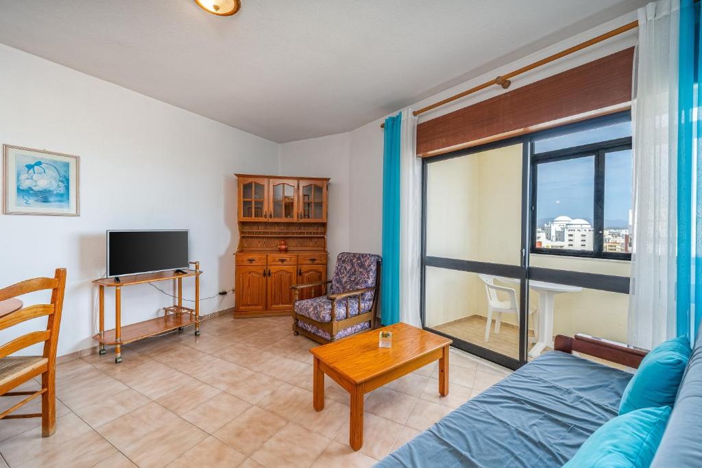a living room with a couch and a tv at Candirocha A8 in Portimão