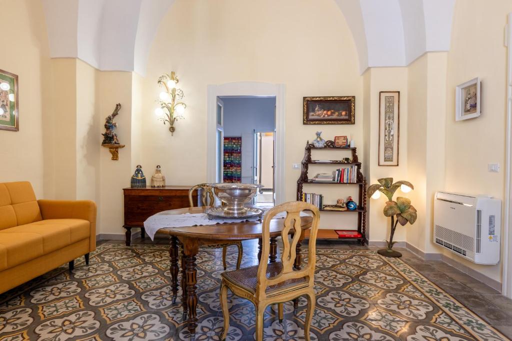 a living room with a table and a couch at Donna Cesarina - Maison de Charme in Maruggio