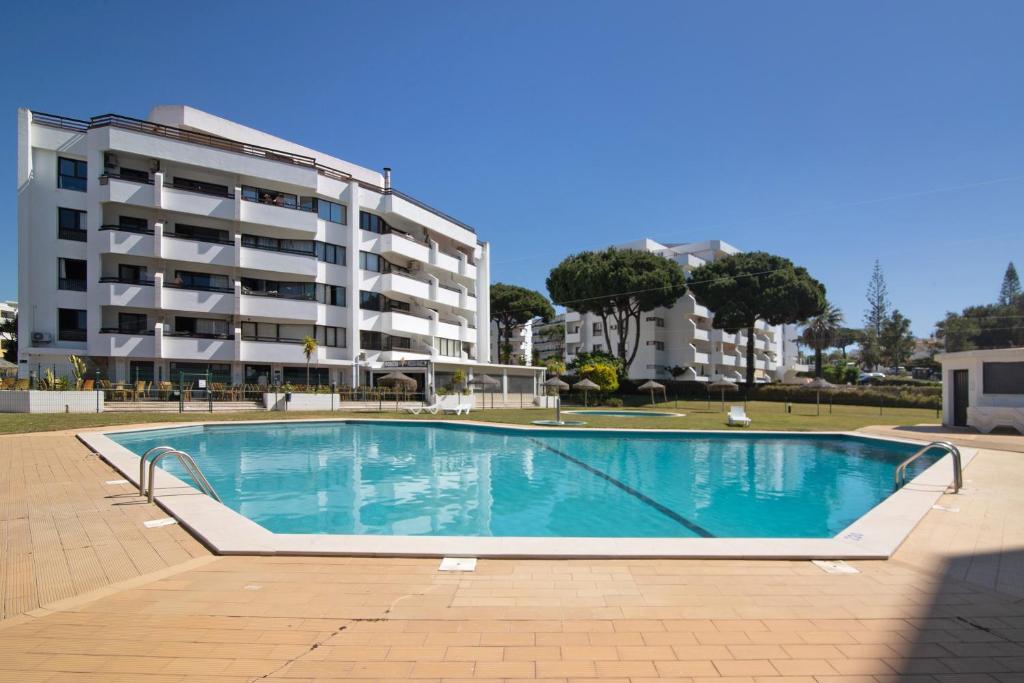 a large swimming pool in front of a building at Tenis Golfmar in Vilamoura