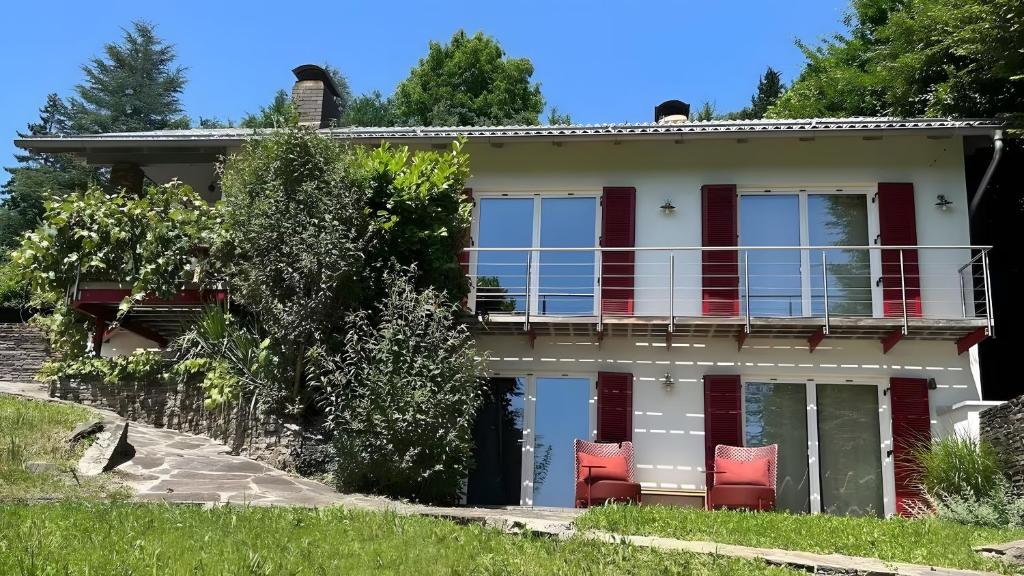 a house with red chairs on the balcony at Traumhaus mit herrlichem Graz Blick in Graz