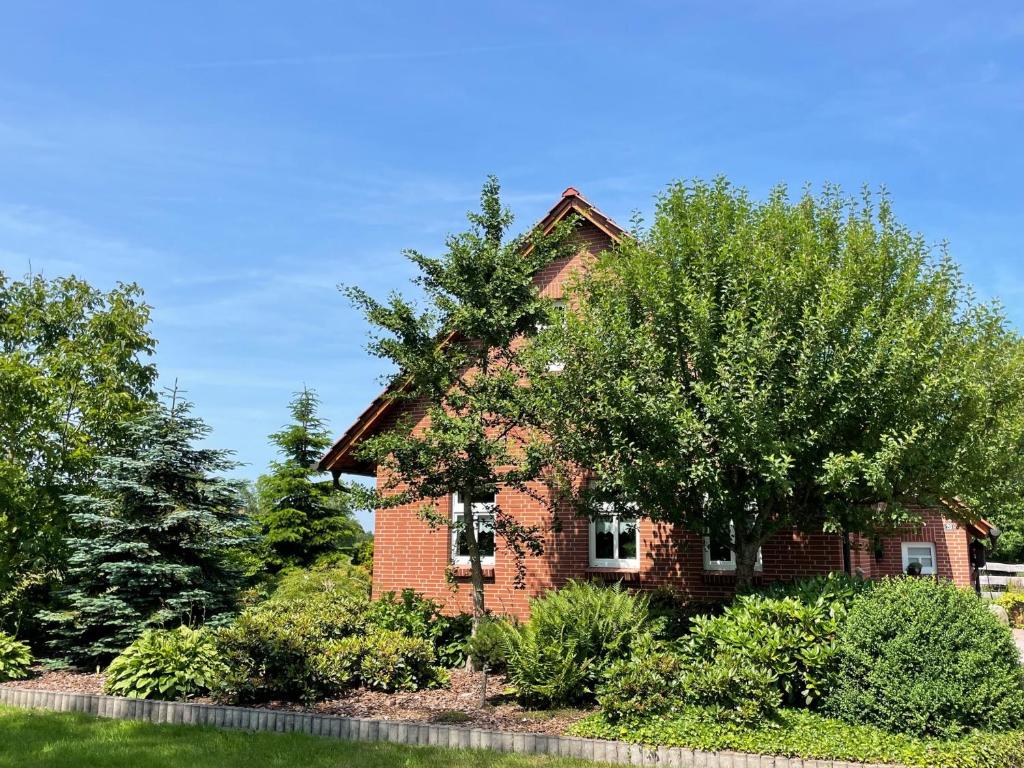 a brick house with trees in front of it at Uhlenhoff Boyken in Bokellerostermoor