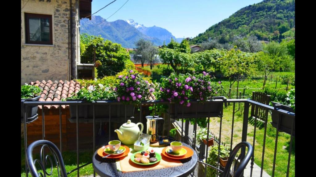 a table with a tea kettle and plates of food on a balcony at Gorgeous 1 double bedroom apartment in Bellagio