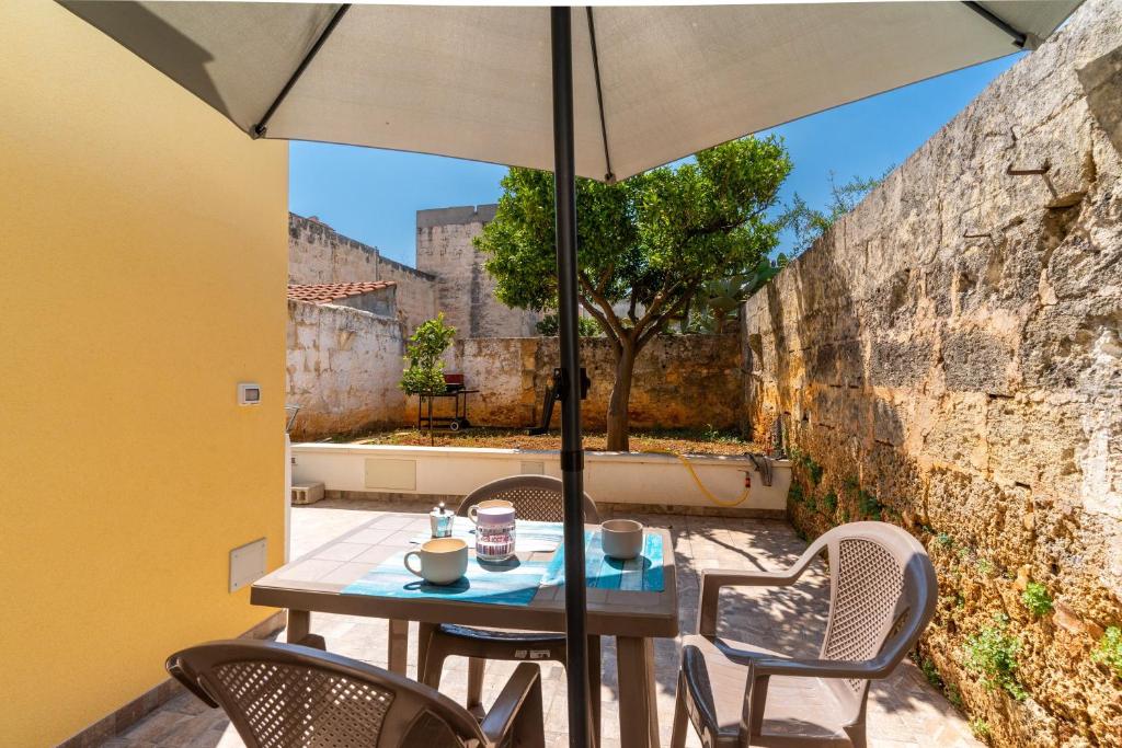 a table and chairs with an umbrella on a patio at Casa Incanto in Presicce