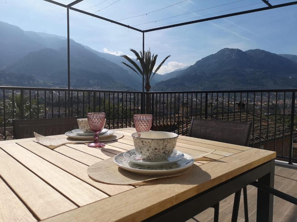 a wooden table with two cups on top of a balcony at Villa Arbona Dalt in Sóller