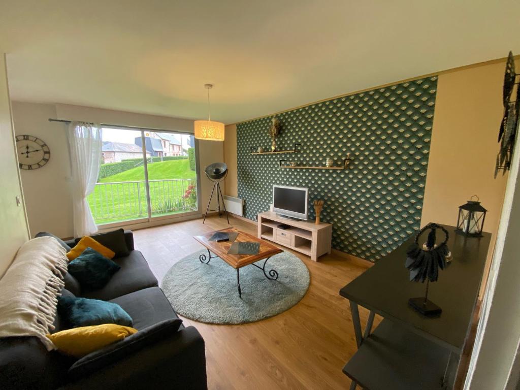 a living room with a couch and a table at Le Lodge d Angèle in Honfleur
