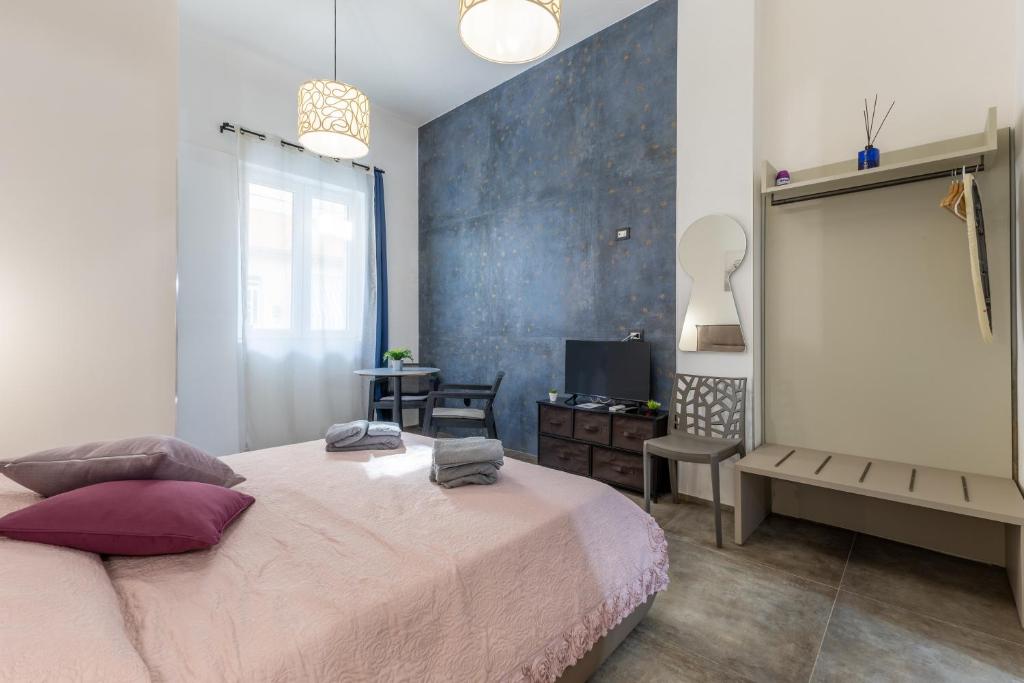 a bedroom with a bed and a desk and a television at Casa Luna in Pozzallo
