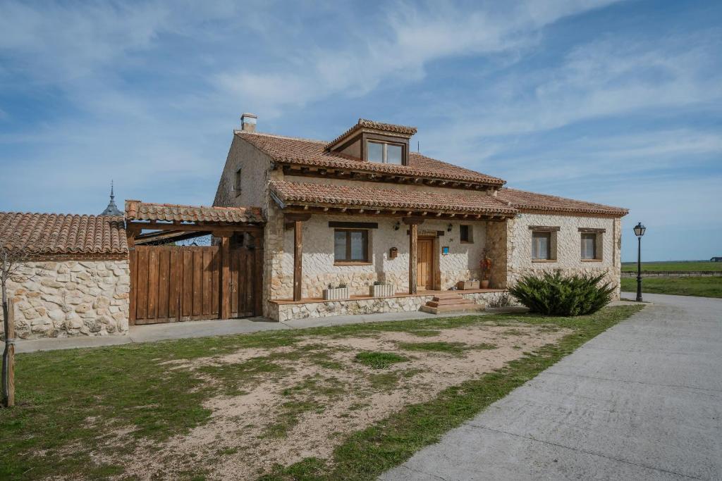 a small stone house with a gate and a fence at La Alameda in Marazuela