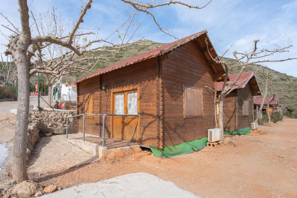 a small wooden cabin with a tree at Falaguera Barraca 2 in Bárig