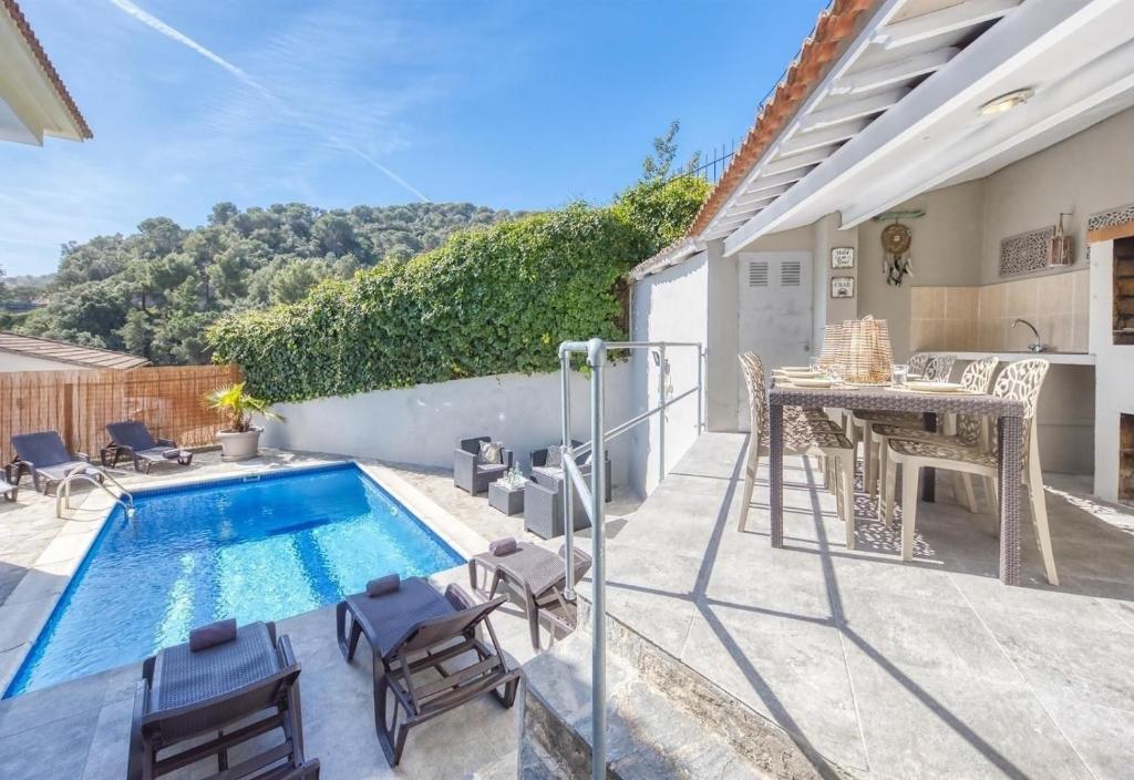 a patio with a swimming pool and a table and chairs at Costacabana - Villa Rosa in Lloret de Mar