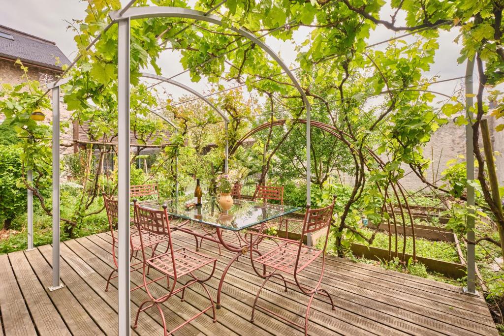 a glass table and chairs on a wooden deck at Chateau De Merande in Arbin