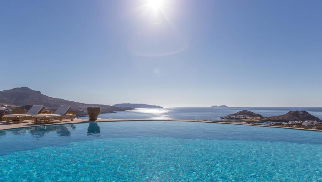 a swimming pool with a view of the ocean at Alegria Mykonos 7 Suites in Kalafatis