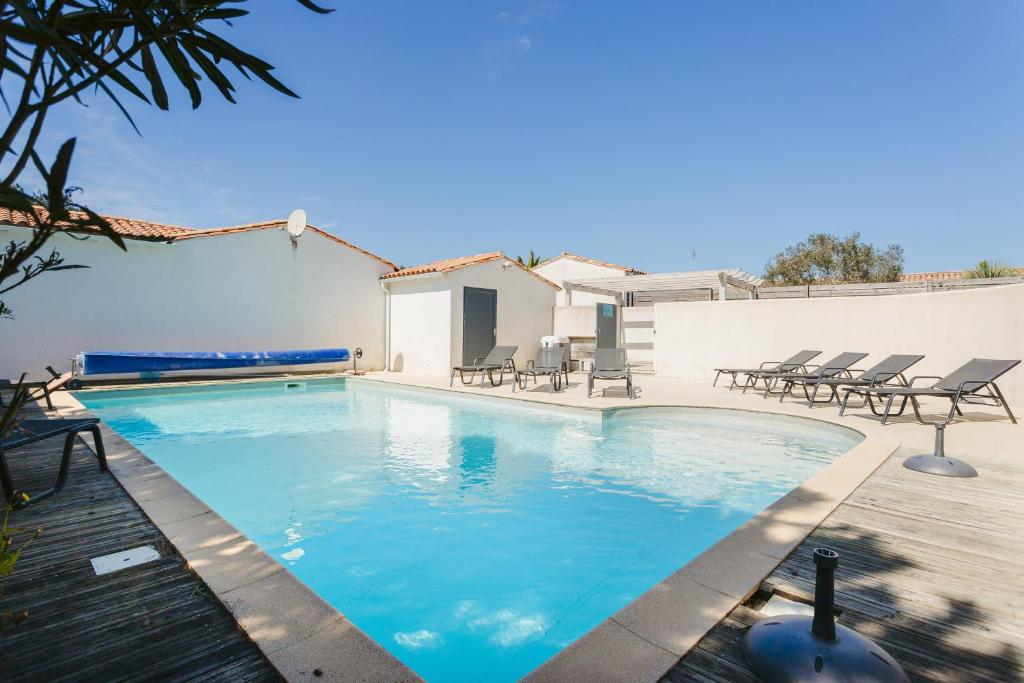 una piscina con sedie e una casa di Pingettes 4 a Le Bois-Plage-en-Ré