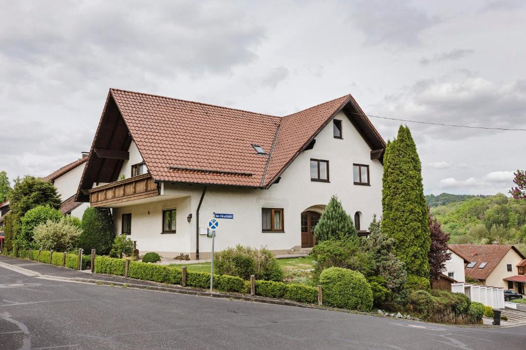 a white house with a brown roof on a street at Gerda Ferienwohnung in Weigendorf