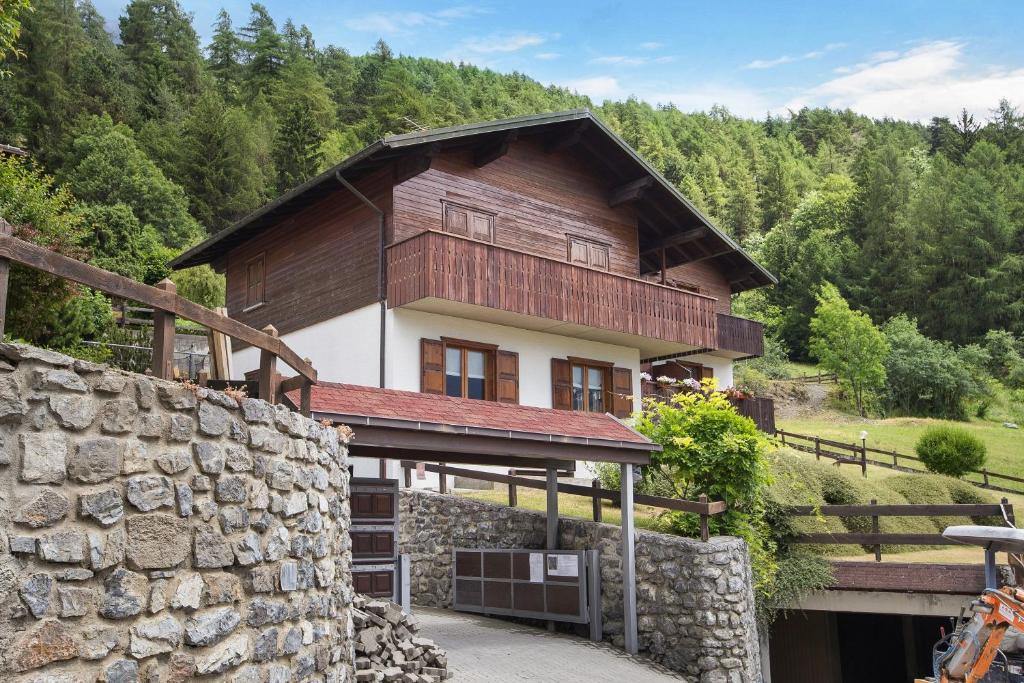 a house in the mountains with a stone wall at Chalet Holly in Bormio