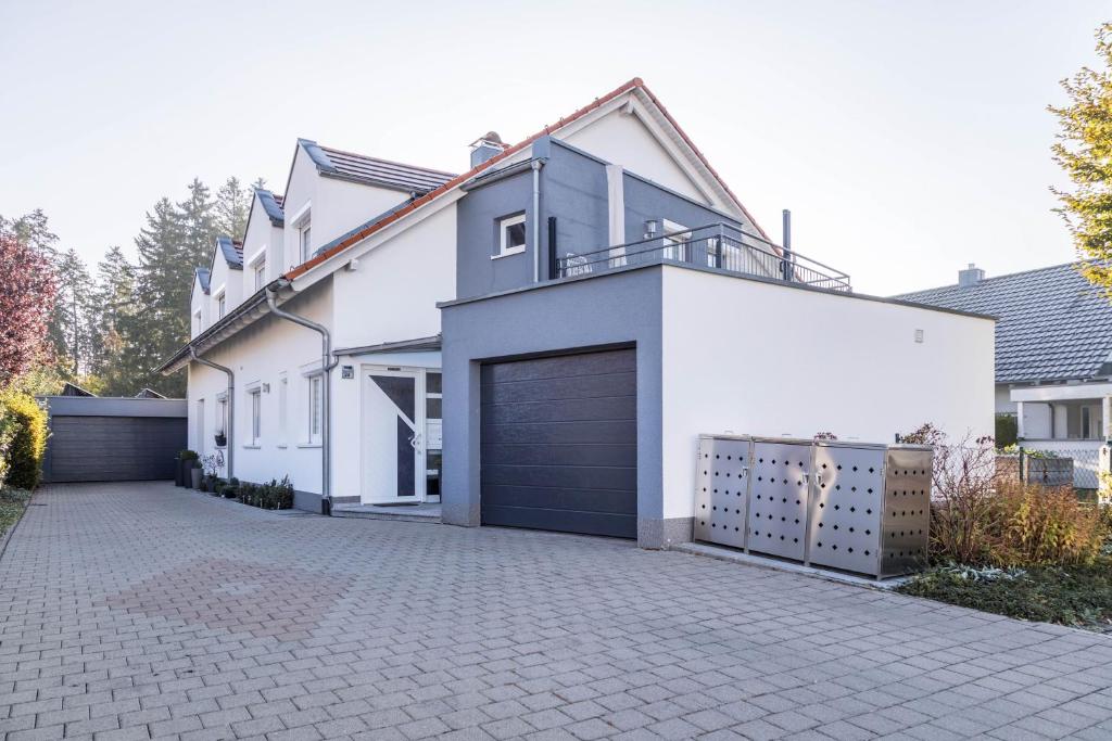 a large white house with a garage at am Salinensee in Bad Dürrheim