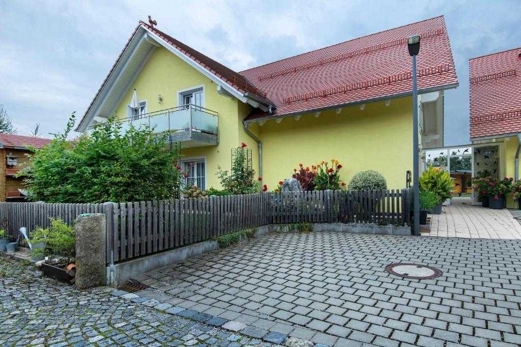 a yellow house with a fence in front of it at Appartement Rosi in Ihrlerstein