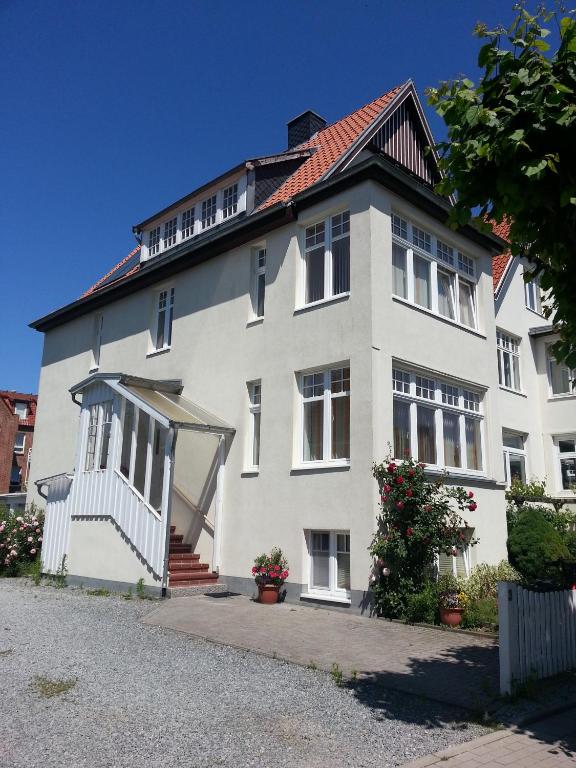 a large white building with a roof at Haus Übersee Wohnung Fidji in Travemünde