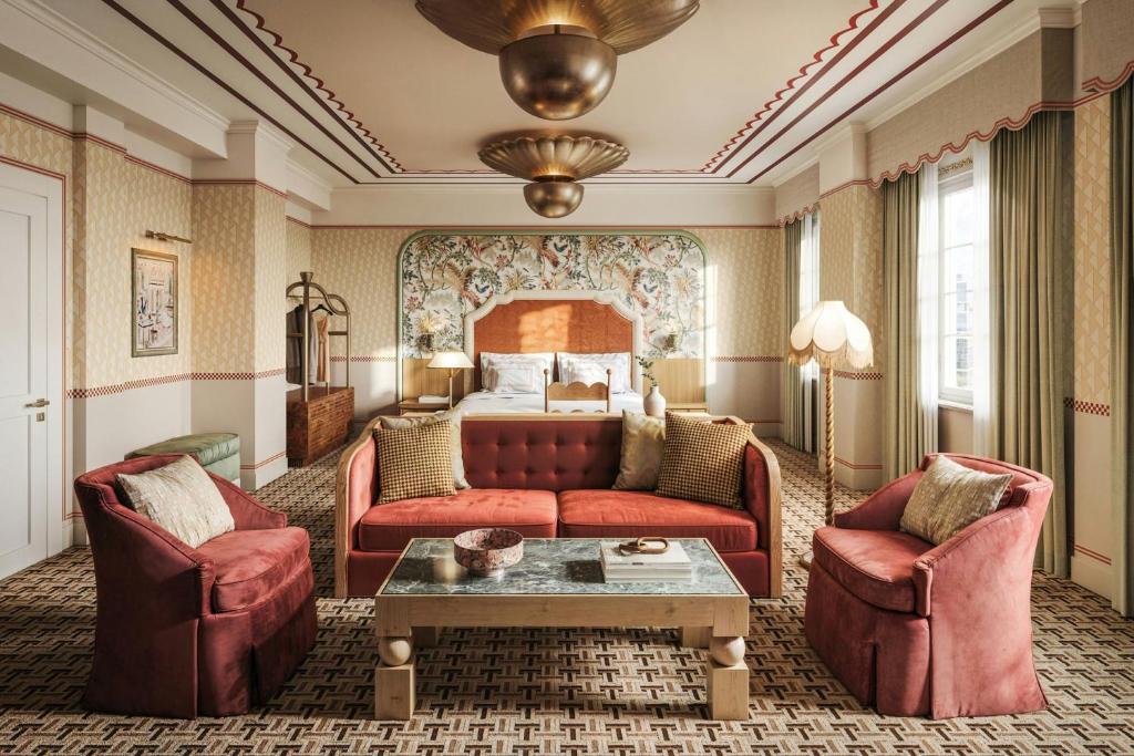 a hotel room with a couch and two chairs and a bed at The Stoneleigh, Autograph Collection in Dallas