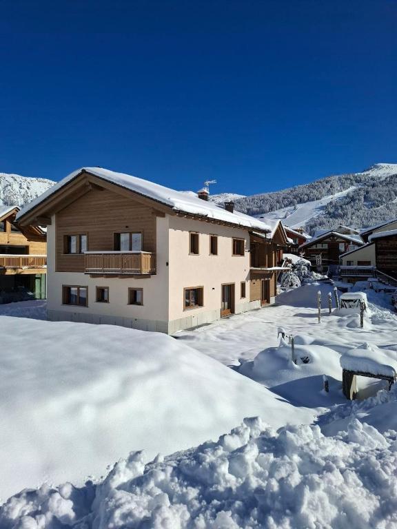 a house in the snow with a lot of snow at Chalet Ale Livigno in Livigno