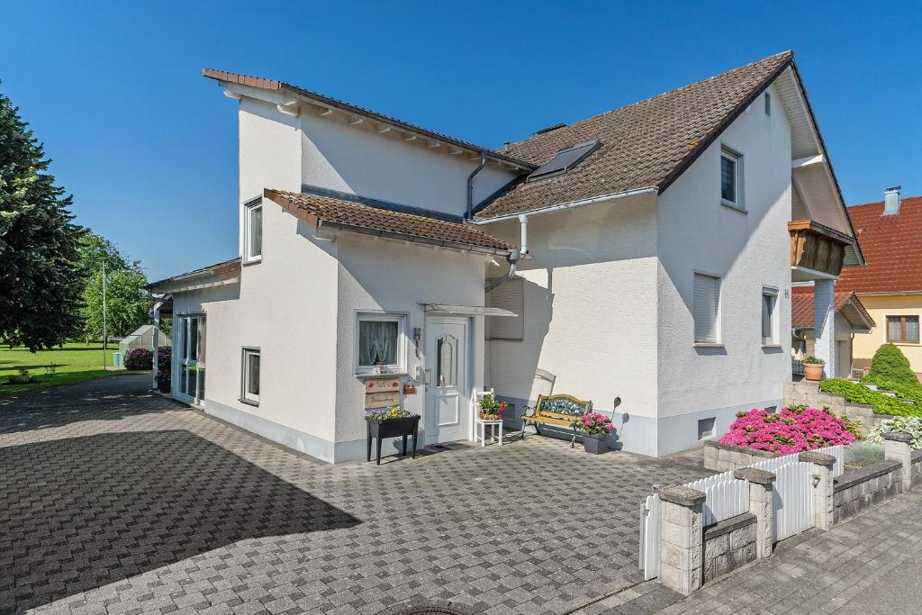 a white house with a brick driveway at Ferienwohnung Viola in Schwanau in Schwanau