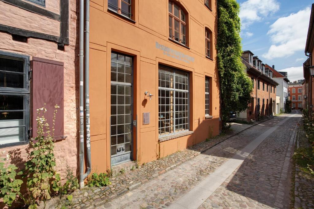 an alley in an old town with an orange building at Alte Seifensiederei 2 in Stralsund