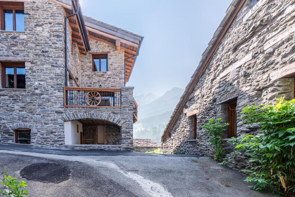 an old stone building with a balcony on a street at Appartement ô Canton in Val Cenis