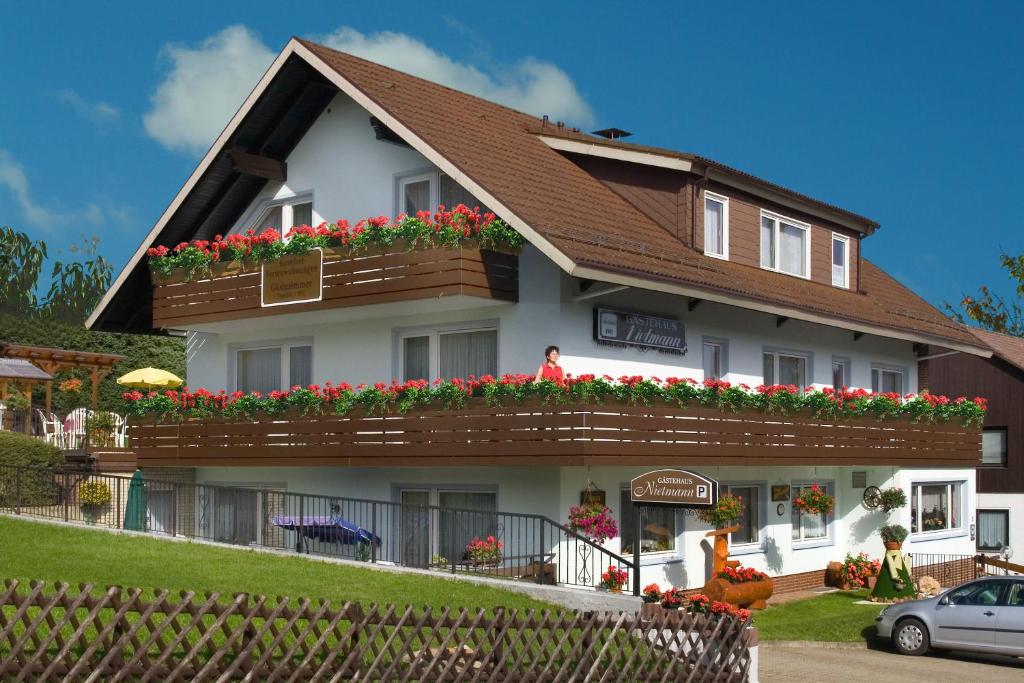 a house with flowers on the balconies of it at Gästehaus Nietmann_ Ferienwohnung 7 in Altenau