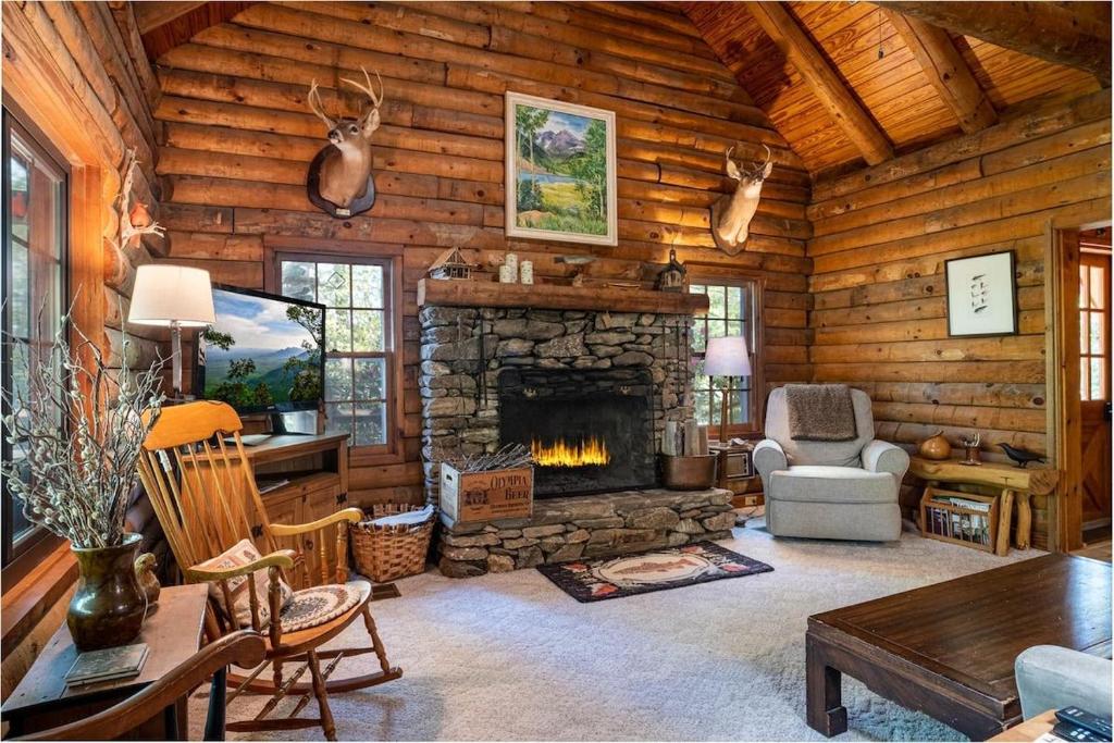 a living room with a fireplace in a log cabin at Great Escape Cabin · Great Escape Cabin in Connestee Falls in Brevard