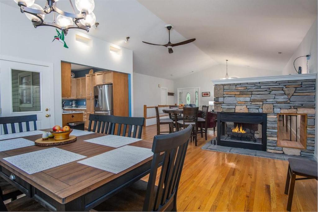 a dining room with a table and a fireplace at Hummingbird Hideaway · Hummingbird Hideaway in Connestee Falls in Brevard