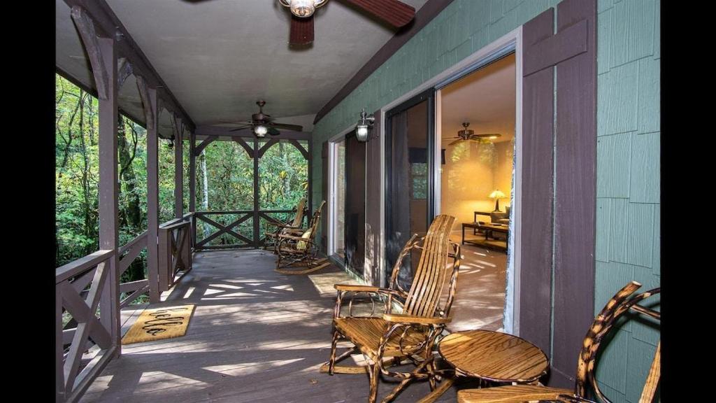a porch with chairs and a table on a house at Shady Creek Cabin · Shady Creek Cabin in Connestee Falls with s in Brevard