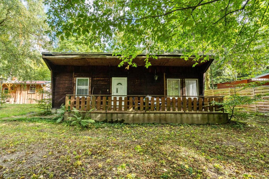 a small house with a wooden fence in front of it at Bugalow 16 - Finnhütte in Niesky