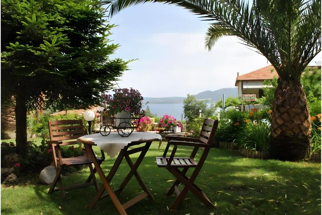 a table and chairs in a yard with a palm tree at Christianna studios in Nikiana