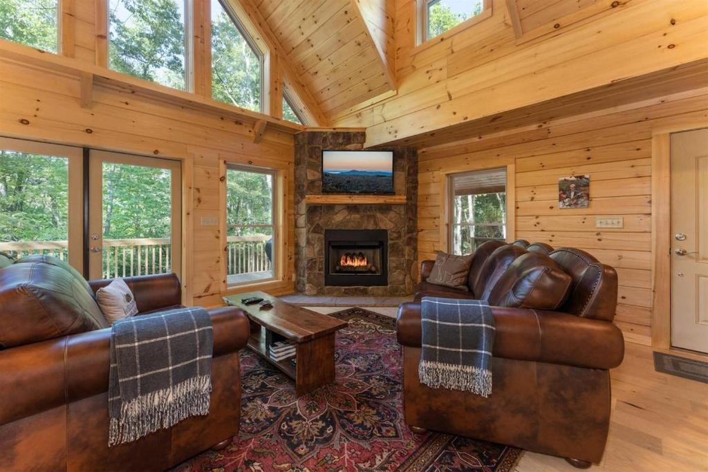 a living room with leather furniture and a fireplace at Hideaway Cabin · Hideaway Cabin in Cedar Mountain in Cedar Mountain