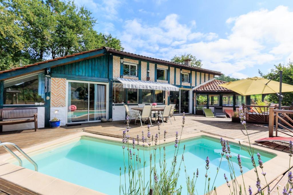 a house with a swimming pool and a patio at Espace, calme, confort in Saint-Michel-Escalus