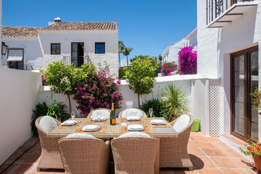 a patio with a wooden table and chairs at Townhouse El Naranjal in Marbella