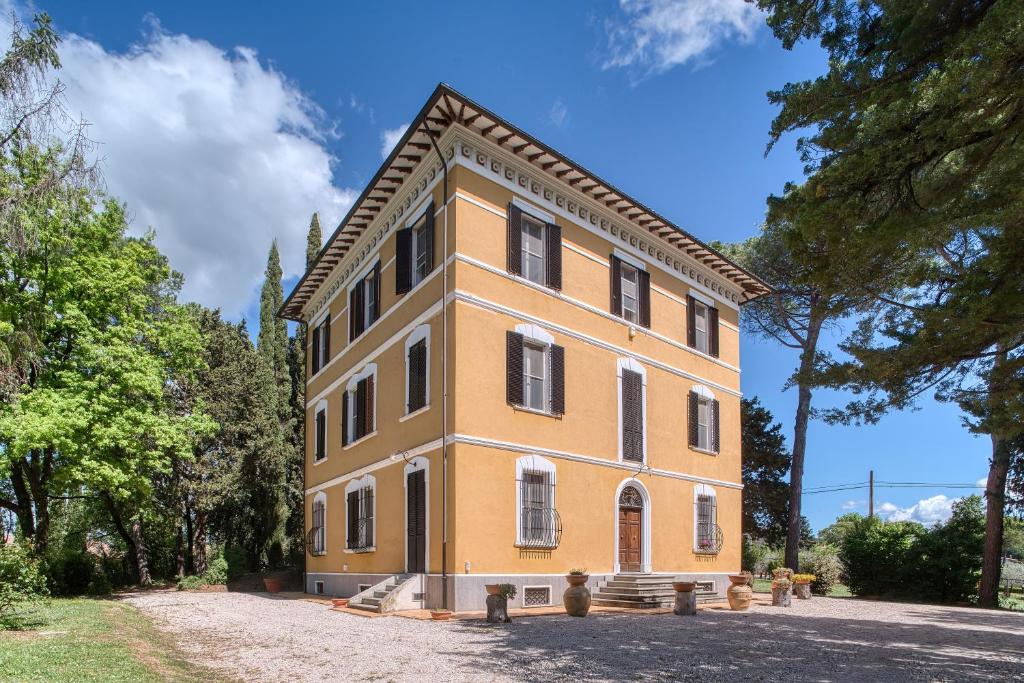 a large yellow building with trees in front of it at Palazzetto Bovini in Perugia