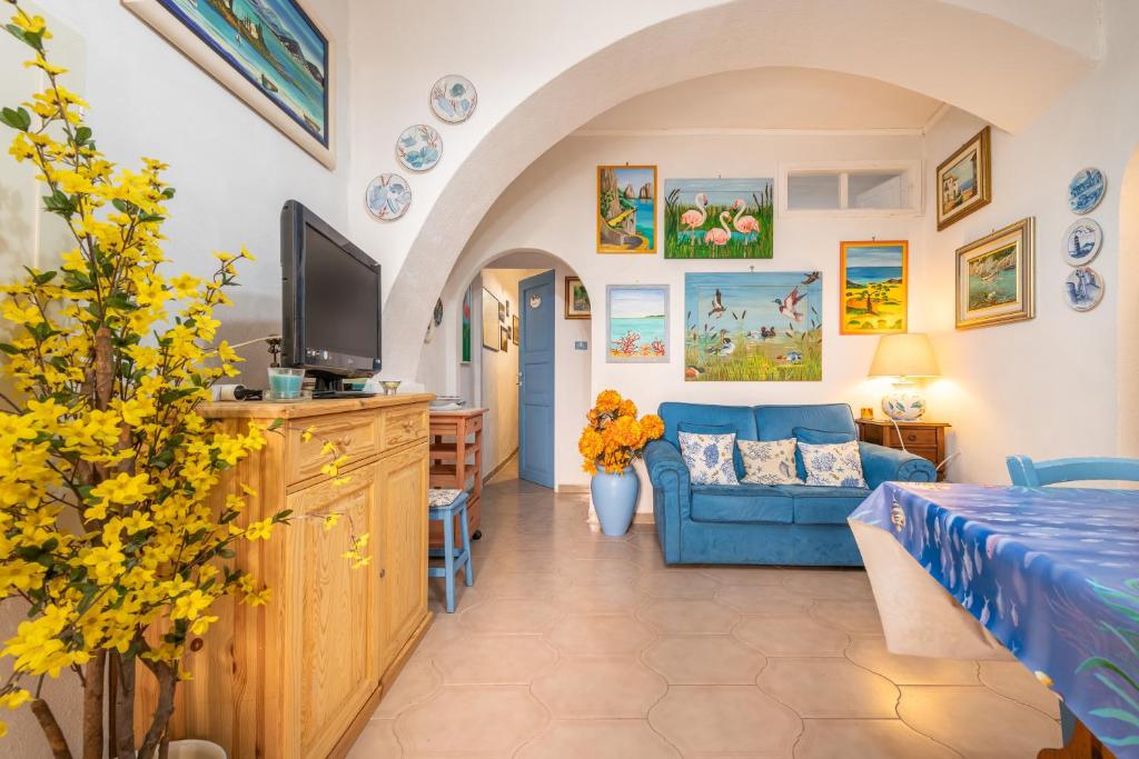a living room with a blue couch and a tv at Casa San Fruttuoso in Carloforte