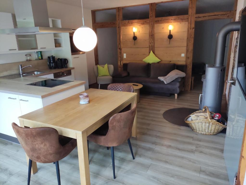 a kitchen and living room with a wooden table and chairs at Ferienwohnung Maulbetsch in Alpirsbach