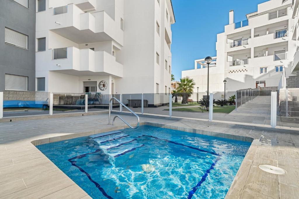 a swimming pool in front of a building at Sungolfbeach El Girasol in Orihuela