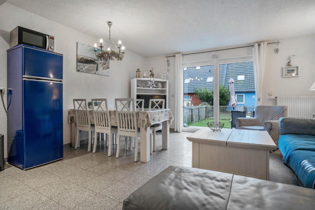 a living room with a blue refrigerator and a table at Ostsee in Pruchten
