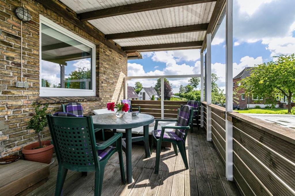 a patio with a table and chairs on a deck at Ferienwohnung Devich in Oersberg